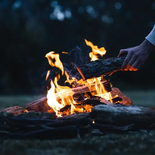 Man adding logs to a fire
